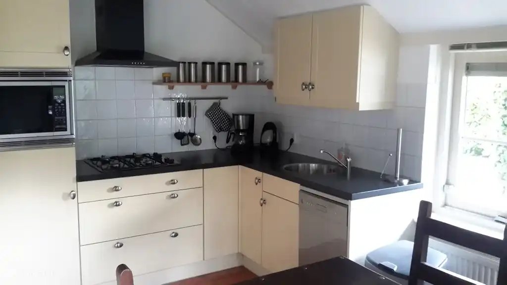 La cuisine avec micro-ondes combiné et lave-vaisselle. Il y a aussi le chauffage au sol ici