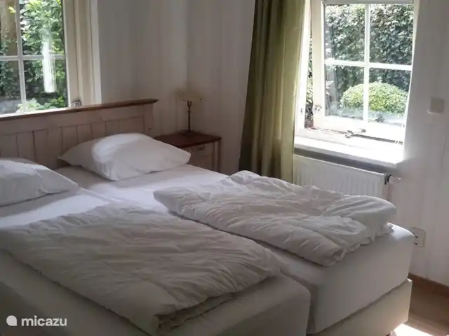 Veluwerijck 8 en Países Bajos, Güeldres, Ermelo - casa de campo Dormitorio grande con 2 sommiers nuevos de 2x80x200 cm con 2 edredones de 140x200 cm y 2 almohadas, 2 mesitas de noche con lámparas de noche, radio despertador, gran armario, silla y suelo laminado