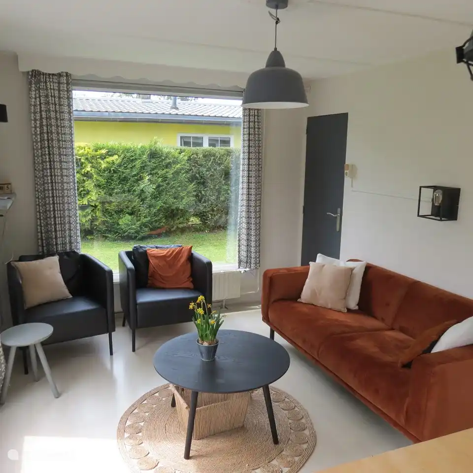 Das Wohnzimmer verfügt über ein Dreisitzer-Sofa, zwei Sessel und zwei Couchtische.