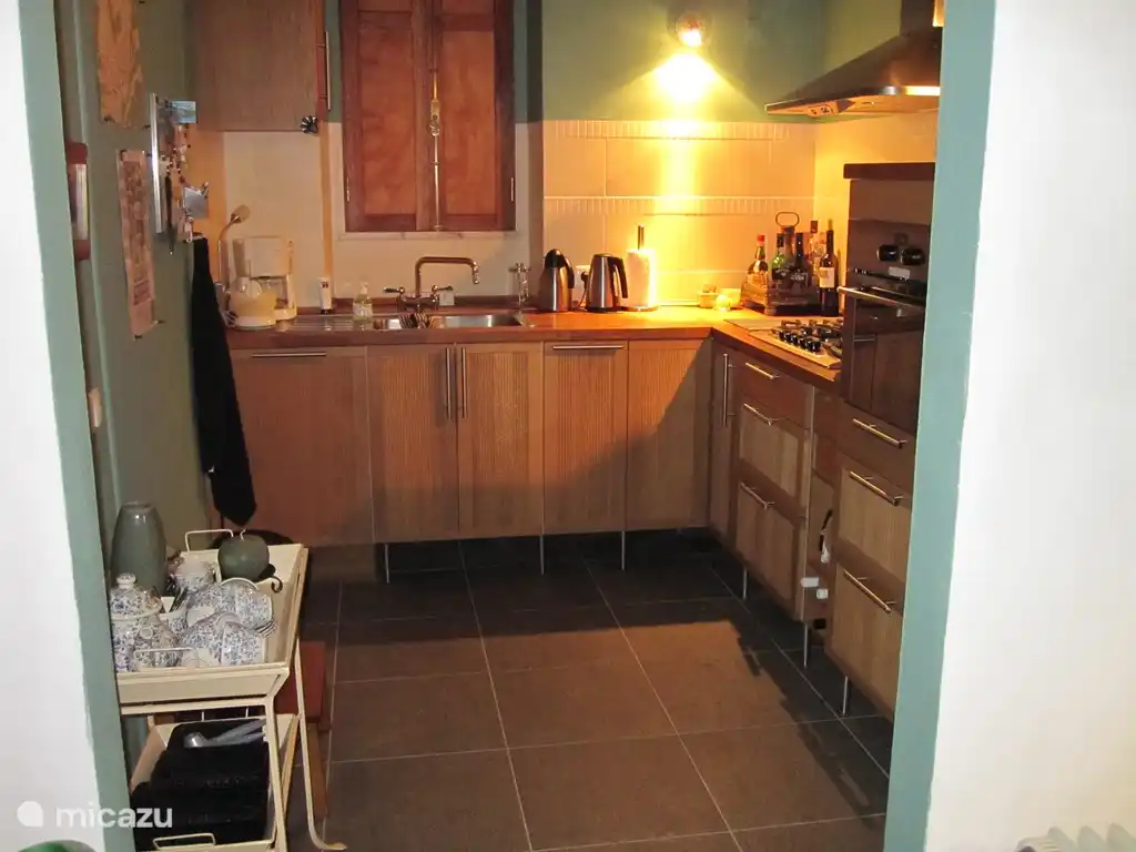 Een ruime keuken om heerlijk in te koken.
Op de vloer liggen grote tegels van Portugees natuursteen in een mooie kleur: verde (=groen).