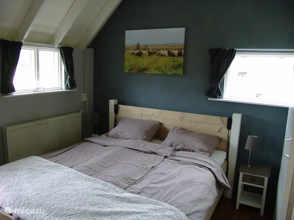 Chambre avec lits confortables réglables électriquement et vue sur les terres agricoles.