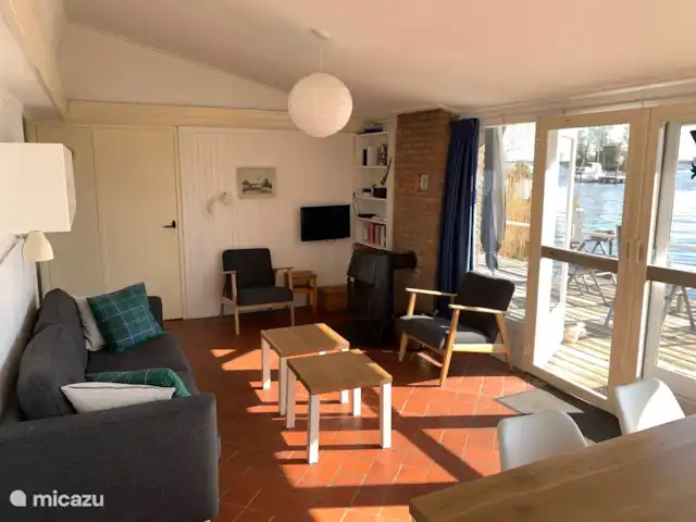 vakantiehuis huren in Nederland, Friesland, Grouw – Heerlijk vakantiehuis aan het water Gezellige woonkamer met zitbank en 2 comfortabele stoelen. Voorzien van TV (digitenne) en openhaard