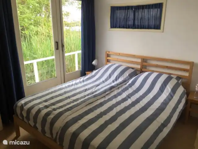 vakantiehuis huren in Nederland, Friesland, Grouw – Heerlijk vakantiehuis aan het water Slaapkamer met tweepersoons bed en openslaande deuren