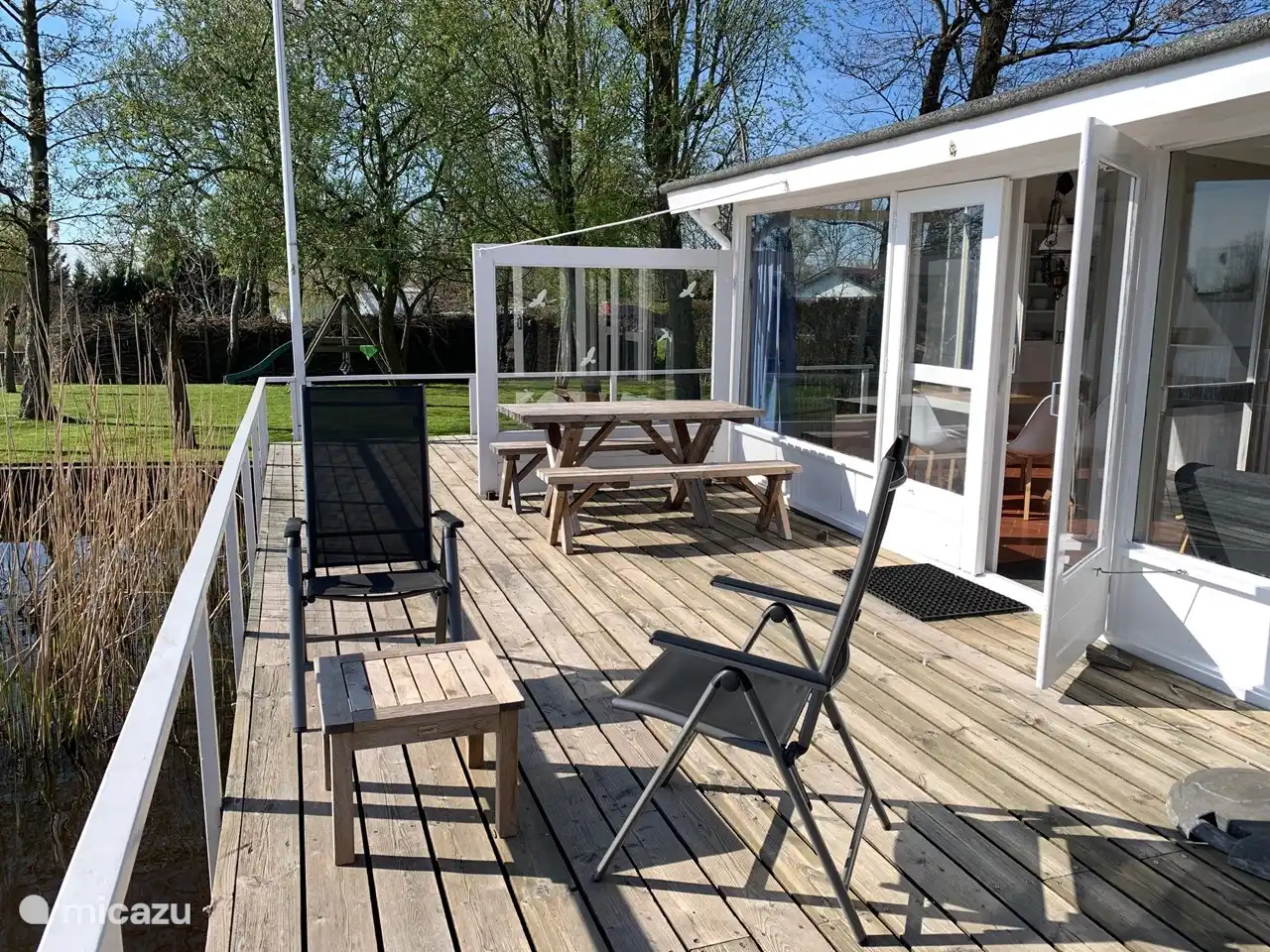 Lovely terrace on the water on the south. Equipped with separate sofa, 6 garden chairs, parasol and dining table with 2 benches
