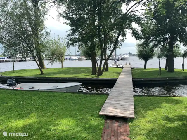 vakantiehuis huren in Nederland, Friesland, Grouw – Heerlijk vakantiehuis aan het water De loopbrug naar het eiland met een eigen aanlegsteiger