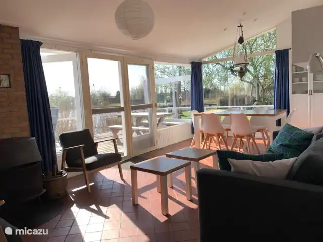 vakantiehuis huren in Nederland, Friesland, Grouw – Heerlijk vakantiehuis aan het water Gezellige woonkamer met eethoek en openslaande deuren naar het terras