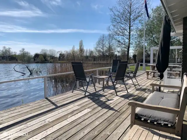 vakantiehuis huren in Nederland, Friesland, Grouw – Heerlijk vakantiehuis aan het water Heerlijk terras aan het water op het zuiden. Voorzien van aparte bank, 6 tuinstoelen, parasol en eettafel met 2 zitbanken