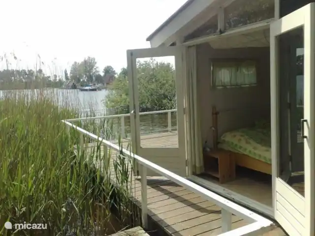 vakantiehuis huren in Nederland, Friesland, Grouw – Heerlijk vakantiehuis aan het water Zijzicht van de grote slaapkamer met openslaande deuren op het oosten