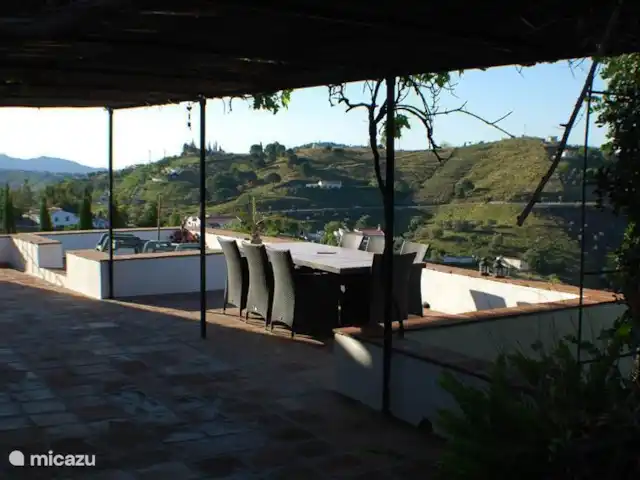 Finca La Estrella de Cómpeta huren in Spanje, Andalusië, Cómpeta - finca Het overheerlijke terras met mooi uitzicht over de heuvels. Als je goed kijkt zie je de druiven door het afdak groeien.