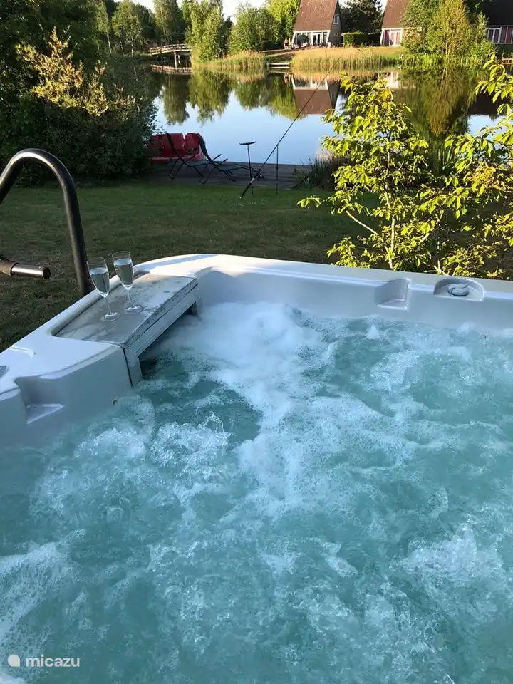 Whirlpool mit Steg und Sonnenliegen.