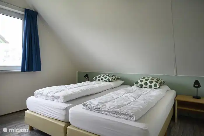 Das Hauptschlafzimmer mit 2 Boxspringbetten und Platz für ein Feldbett.