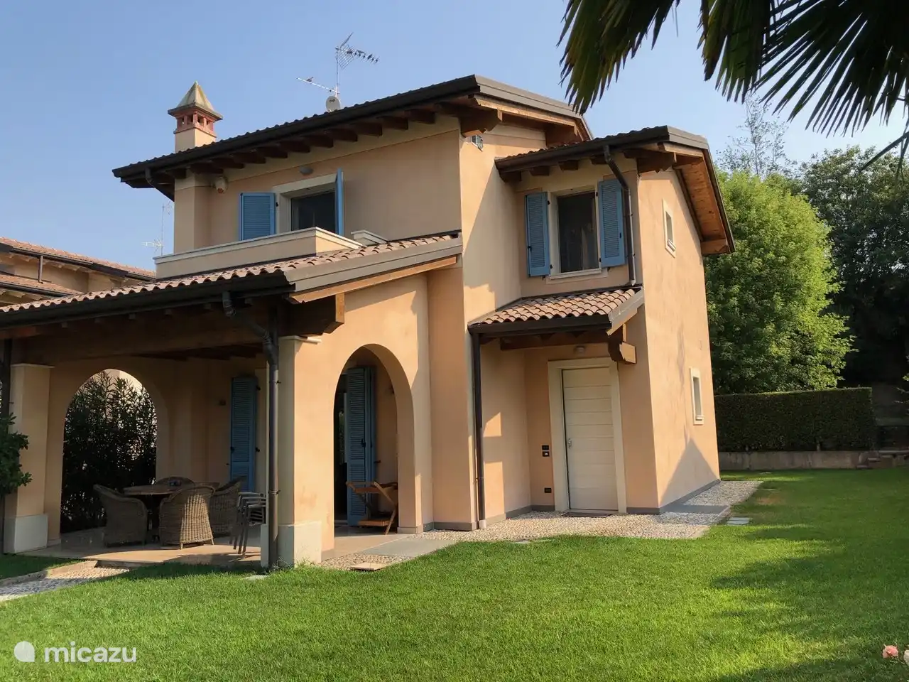 Front mit Garten und überdachter Terrasse.