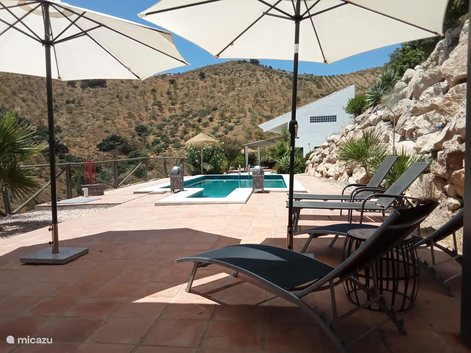 Hamacas y sombrillas junto a la piscina