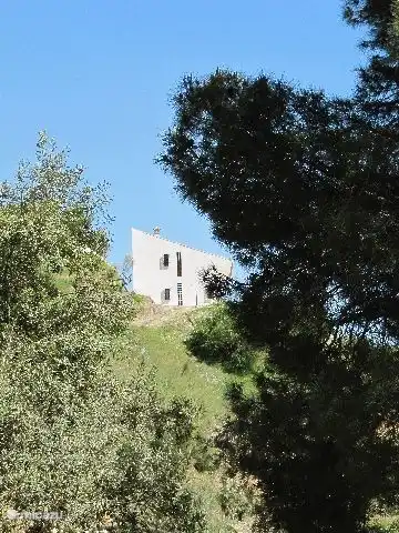 La finca vista desde el valle. El lado oeste de la casa tiene bloques de construcción de colores que dan una hermosa luz de color en el pasillo de la casa. Caminas directamente al aire libre donde crecen muchos almendros y olivos. Aquí y allá también encontrará naranjos, limoneros y tilos.