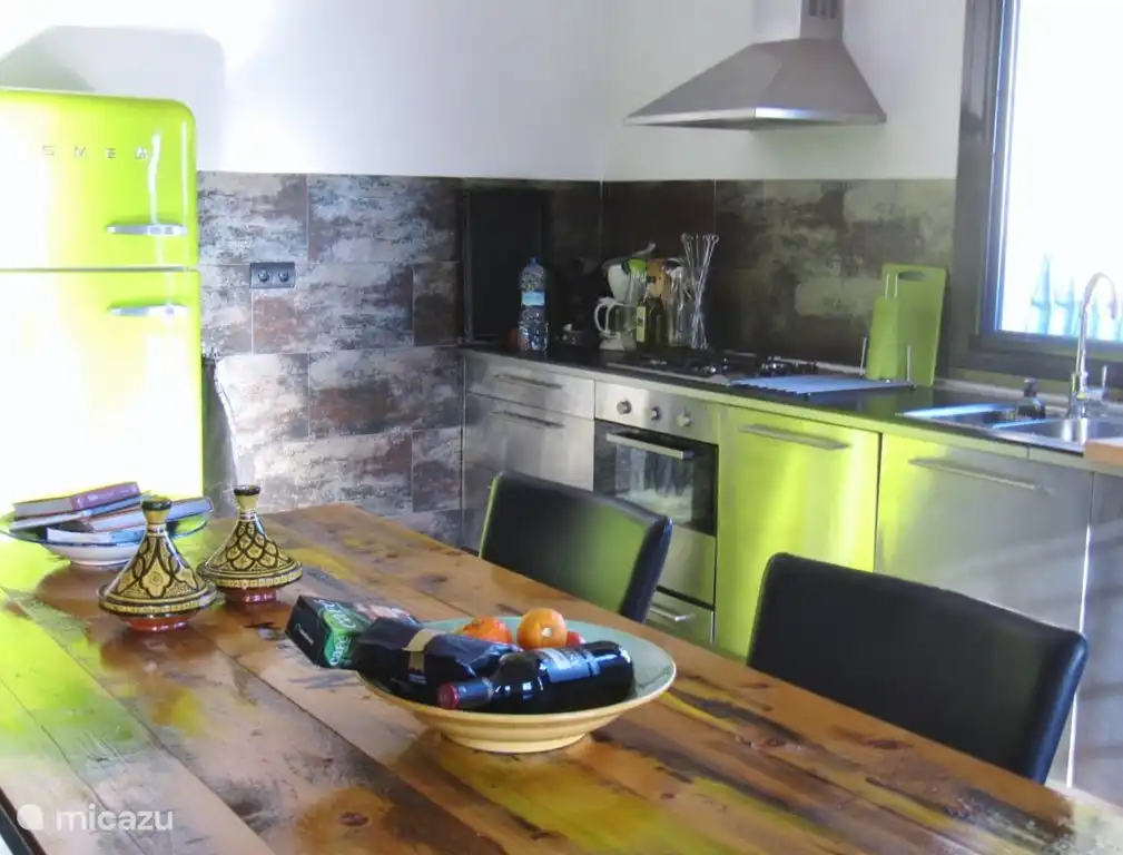 La cocina muy lujosa es una cocina abierta de acero inoxidable con todos los accesorios. Hay una mesa grande para 6 personas.