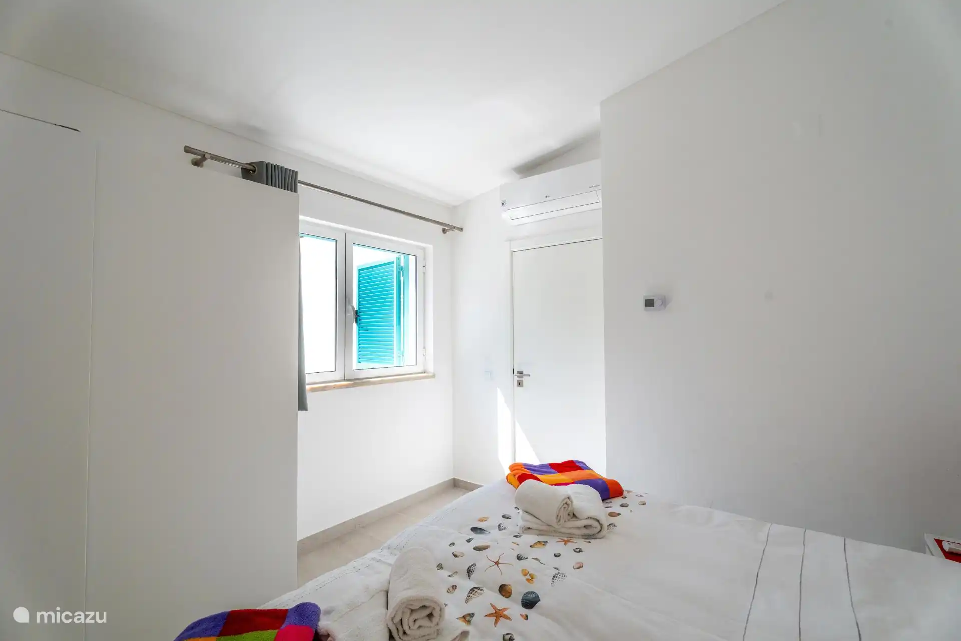 Chambre spacieuse à l’étage avec placards et vue sur le jardin et la piscine.