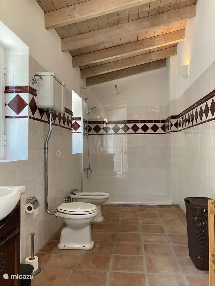 Das Badezimmer ist geräumig, mit einer geräumigen begehbaren Dusche, einem Waschbecken, einer Toilette und einem Bidet.