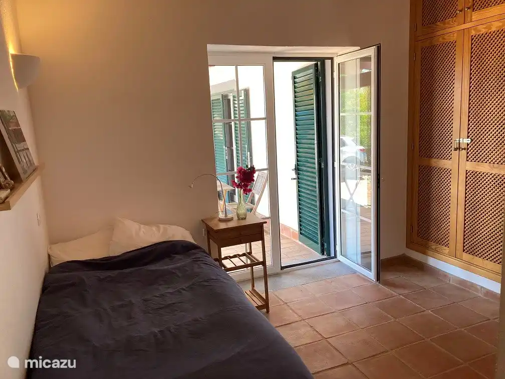 Zweites Schlafzimmer. Das Zimmer hat Terrassentüren zur Terrasse an der Seite des Hauses.
