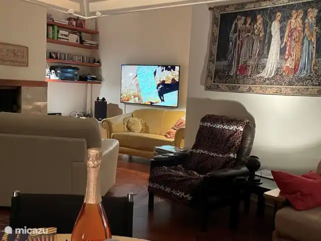 Location de Vacances Italie, Ombrie, Bettona, villa - Belle maison de vacances avec piscine Séjour confortable avec cheminée, coin salon TV, table à manger, audio, livres, etc. Porte avec moustiquaire donnant sur balcon.
