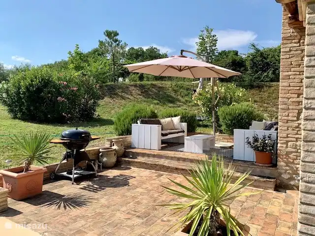 Schöne Terrasse an der Seite des Hauses und der Grill steht bereit.