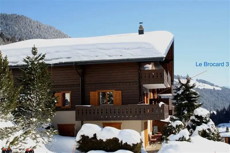 Het chalet vanaf de parkeerplaats gezien. De pijl wijst naar ons appartement.