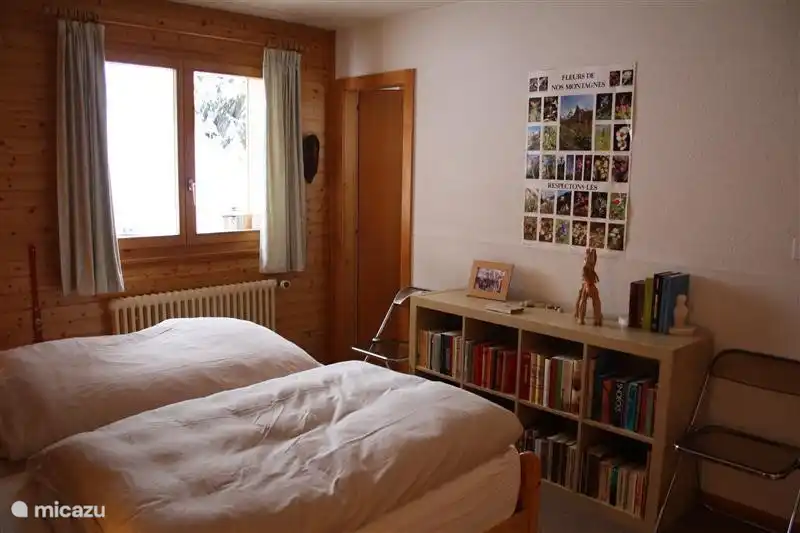 De 2-persoonsslaapkamer met achterin de deur naar de kleine, aangrenzende badkamer.