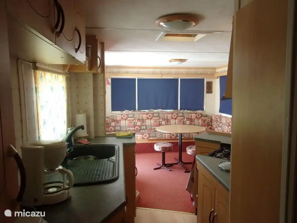 Ein Blick auf die geräumige Lounge aus der Küche mit 4-Flammen-Gaskomfort, Grill, Backofen, Kühlschrank, Mikrowelle und Kaffeemaschine.