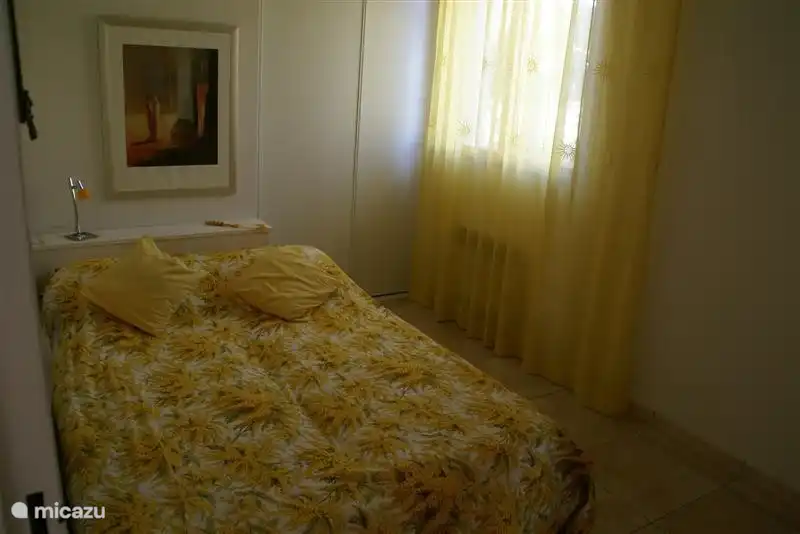 Chambre jaune en bas avec lit double