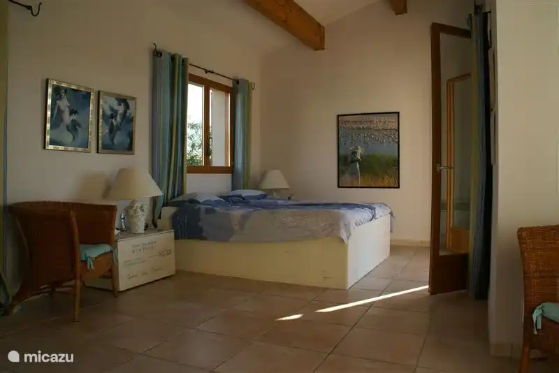 Chambre principale au rez-de-chaussée, portes à droite sur la terrasse, fenêtres à gauche sur le jardin