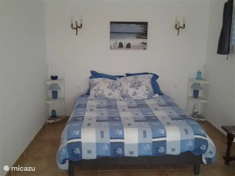 Das Schlafzimmer im Erdgeschoss mit Terrassentüren zur Terrasse.