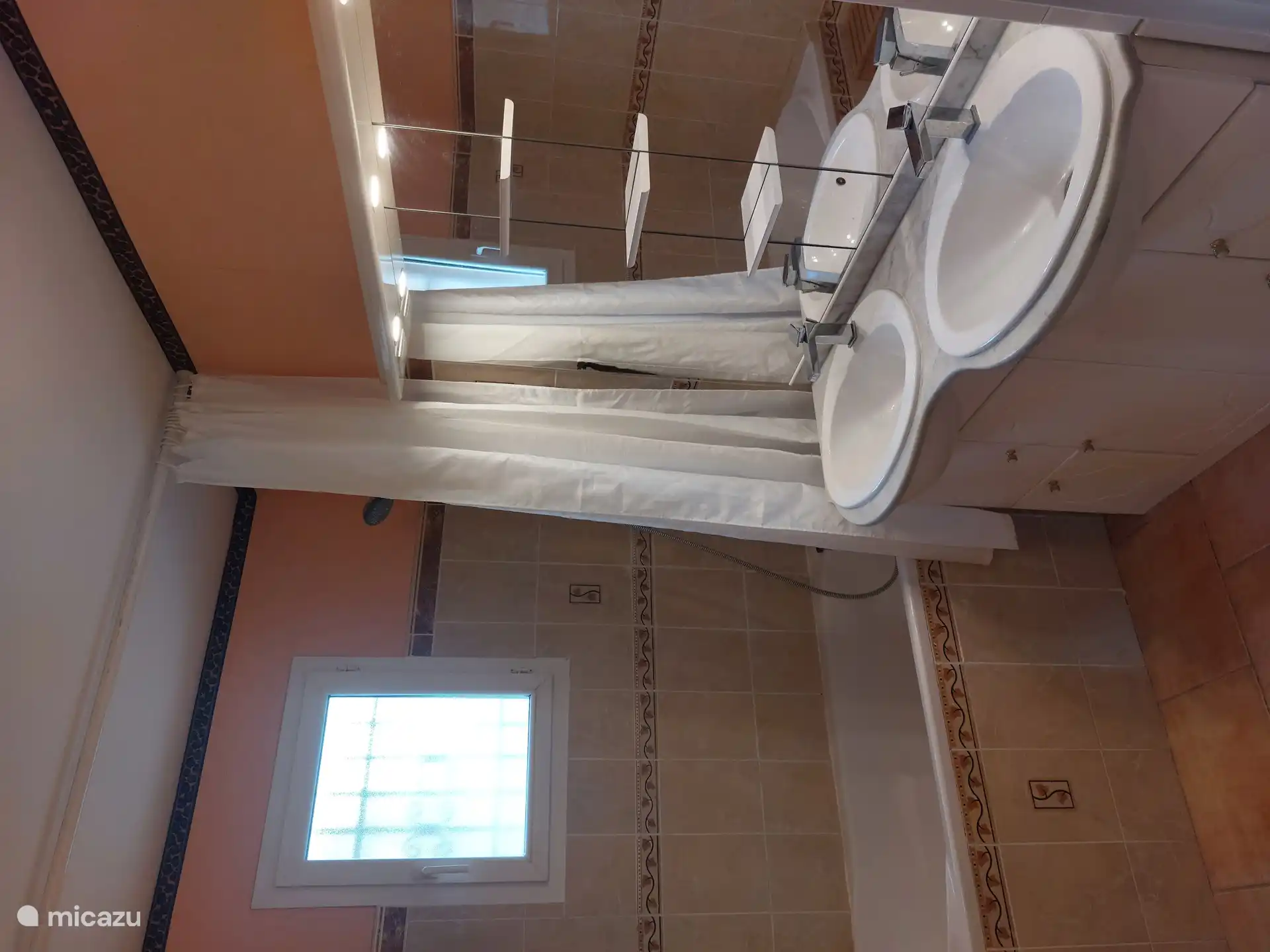 Badezimmer im Erdgeschoss mit Badewanne, Dusche und Doppelwaschbecken. Es gibt eine separate Toilette.