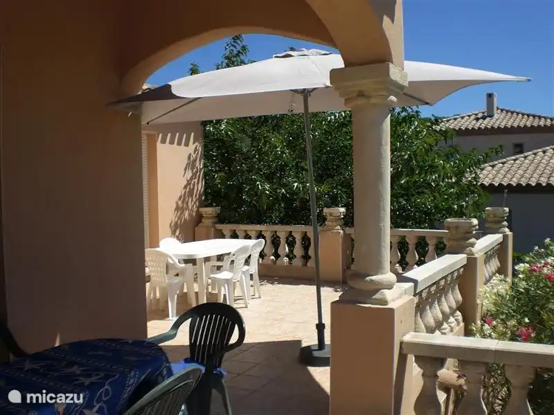 Die Terrasse im Erdgeschoss mit einer Fläche mit Schatten und einem Bereich mit Sonne.