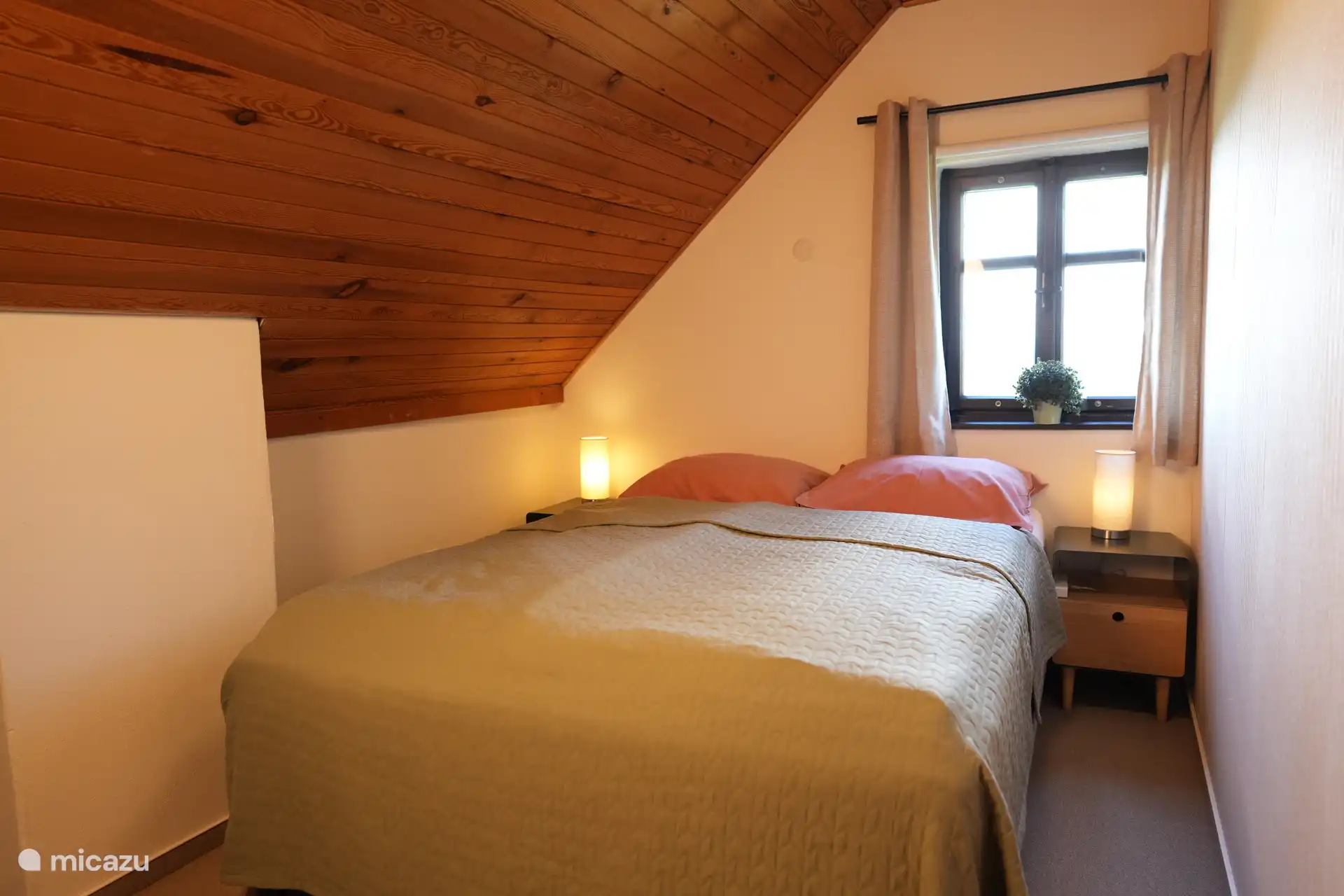 Das dritte Schlafzimmer mit einem Boxspringbett für 2 Personen. Aus dem Fenster blickt man auf einen schönen Blick ins Tal