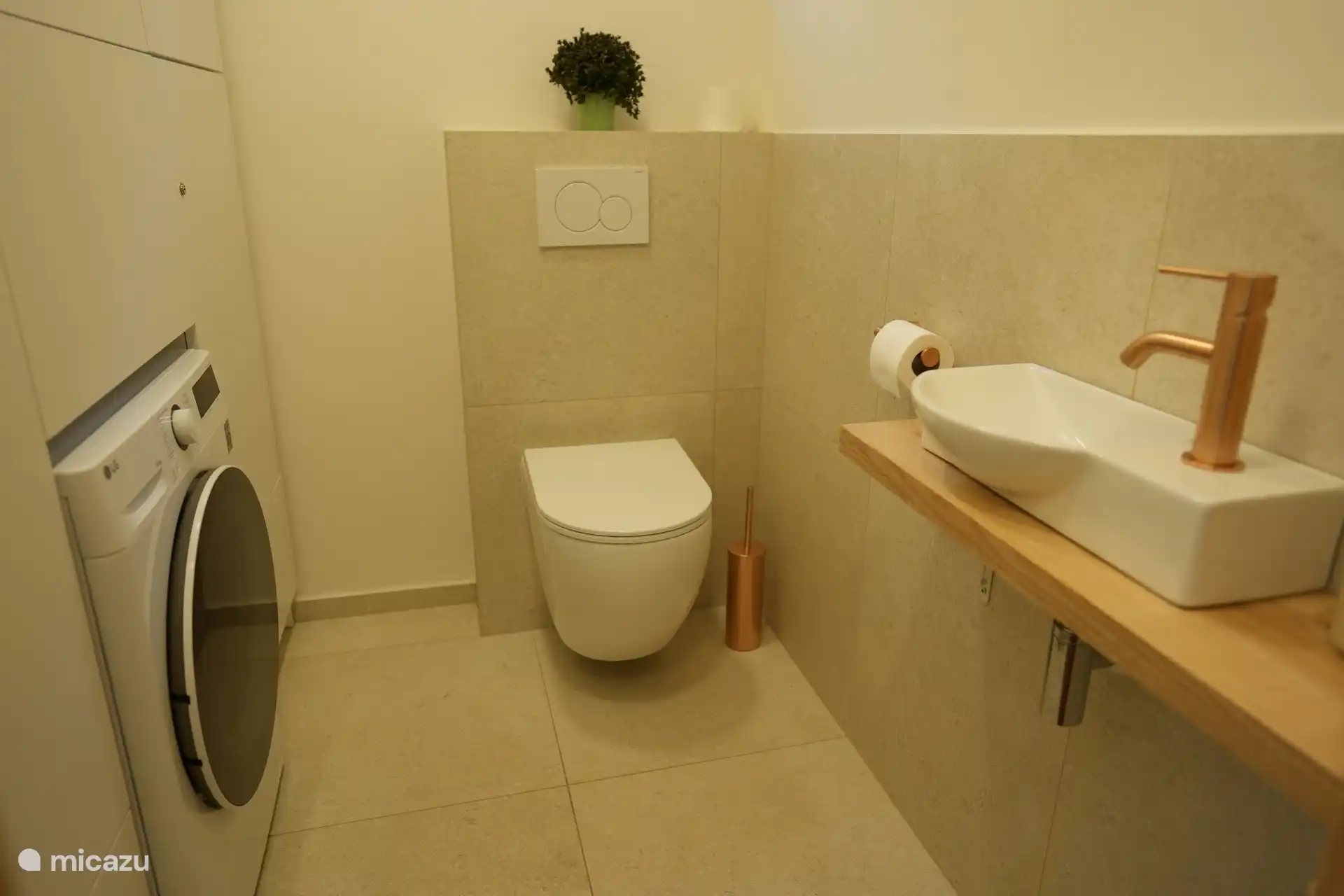 eine extra separate Toilette mit Waschmaschinen- und Trocknerkombination.