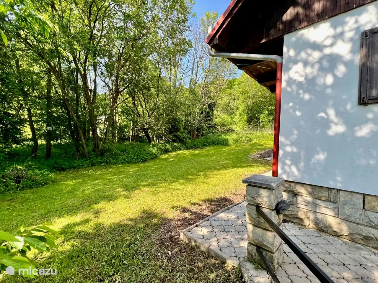 Auf der Rückseite des Hauses können sich die Kinder frei auf dem Rasen austoben, während Sie sie leicht im Auge behalten können. Eine sichere und entspannende Umgebung für die ganze Familie.