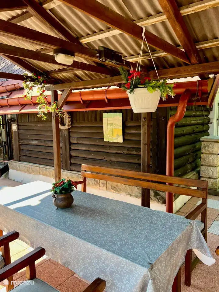 Genießen Sie die überdachten Sitzgelegenheiten auf der großzügigen Terrasse. Ein komfortabler Ort zum Entspannen, geschützt vor Sonne und Regen, mit Blick auf die schöne Umgebung.