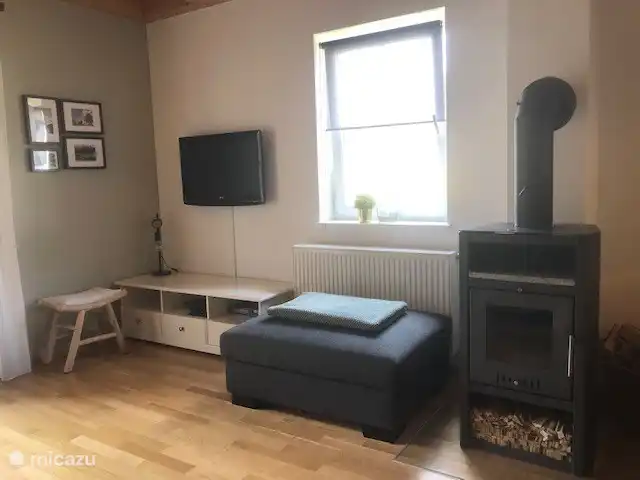 Chalet Kötschach en Austria, Carintia, Kötschach-Mauthen - casa vacacional Acogedor salón con estufa de leña y TV satélite holandesa. También una otomana para agregar si es necesario