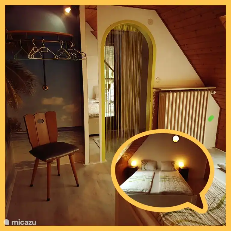 Das Schlafzimmer im Obergeschoss. Ein Doppelbett mit einer Tür zum Balkon.