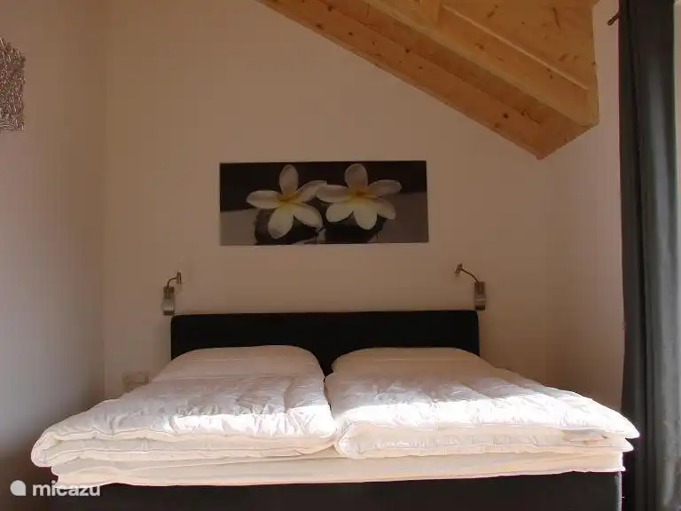 Chambre I avec un luxueux lit à ressorts pour 2 personnes avec portes-fenêtres donnant sur un grand balcon orienté au sud.