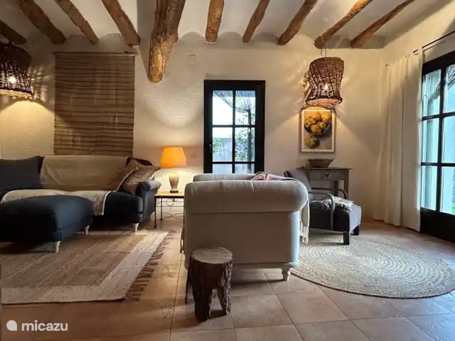 finca en España, Pirineos españoles , Juseu – Casa Milan en Juseu Finca Retreat La sala de estar con puertas que dan al jardín con una terraza cubierta y al patio.