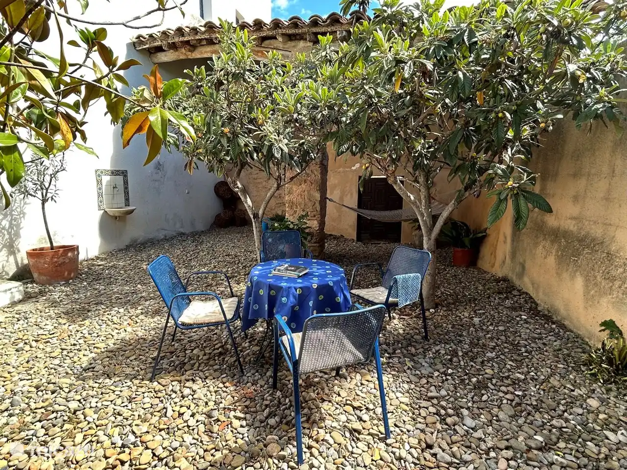 The quiet courtyard with table and chairs and a hammock.