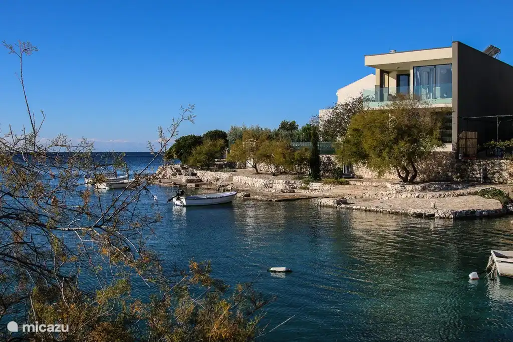 Das Haus von der anderen Seite gesehen, mit der Bucht im Vordergrund und mit Blick auf das offene Meer.