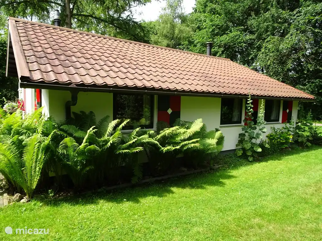 Aan de  achterzijde van de bungalow bevinden zich de slaapkamers met openslaande ramen met ten dele voorzien van horren.