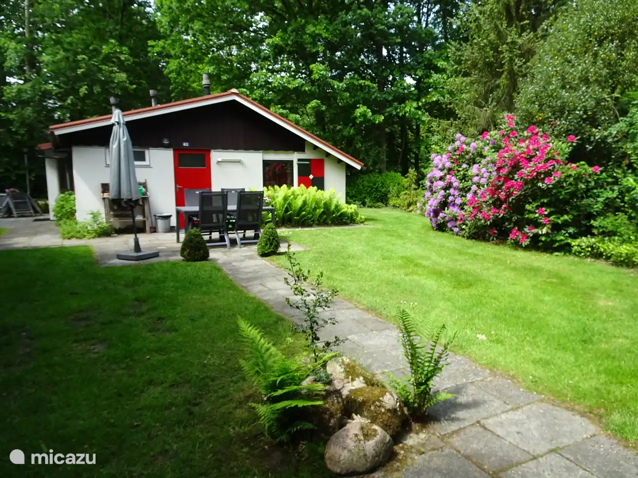 
Bij de voordeur is een tweede terras  . Als U bij mooi weer  niet in de felle zon wilt zitten kunt U gebruik maken van een parasol .  Hier bevindt zich  een degelijke  tafel met vier hartman stoelen welke verstelbaar zijn in diverse standen.