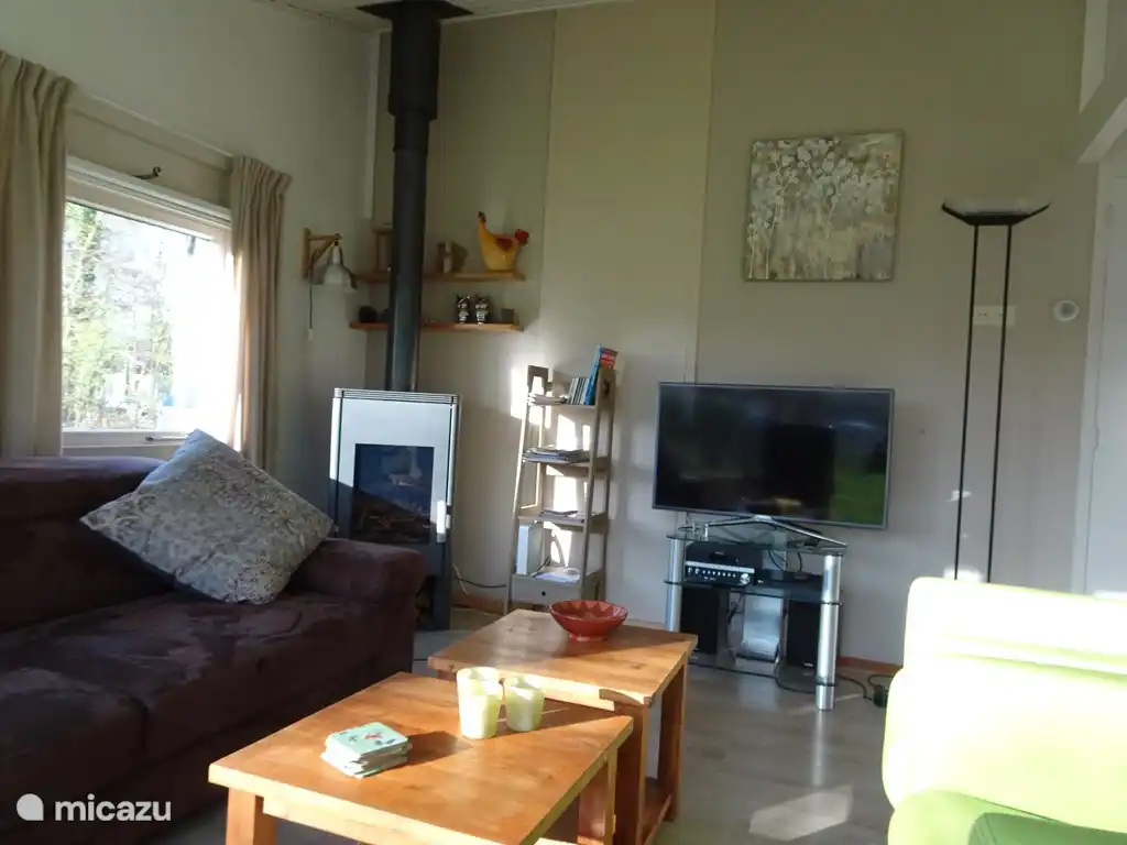De gezellige woonkamer beschikt over een driezitsbank, drie fauteuils, een houtkachel, smart TV , een moderne digitale radio ontvanger (DAB+), welke tevens is voorzien van een cd speler. Daarnaast is er ook een nieuwe bluray speler aanwezig. Er is een sfeervolle verlichting met  veelal dimlicht.

