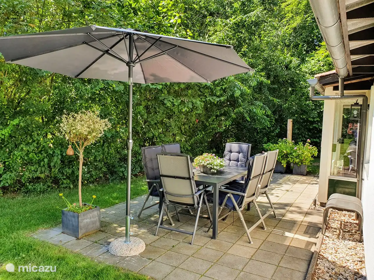 La terrasse ensoleillée avec salon de jardin.