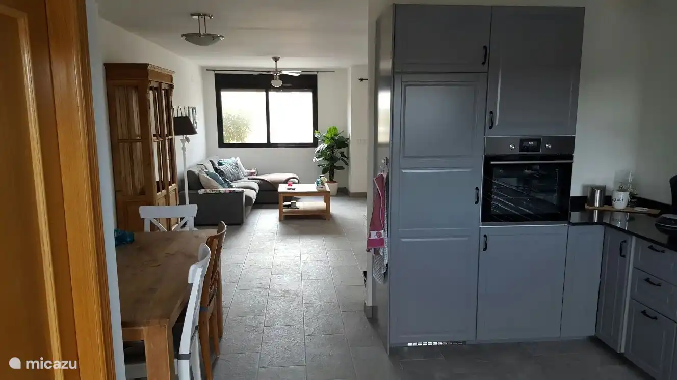 Blick von der Küche auf den Wohnbereich. mit Esstisch für 7 Personen und angrenzender Toilette.