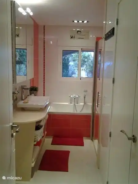 Badezimmer mit Doppelbadewanne, Dusche und separatem WC.