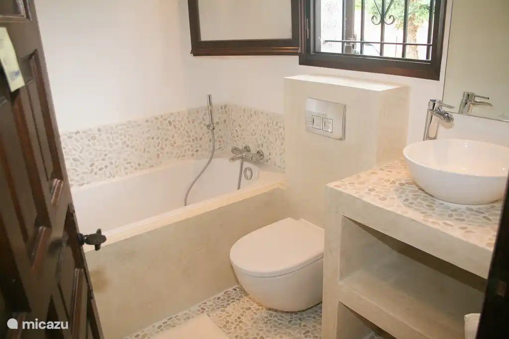 Badezimmer mit Waschbecken, Badewanne und WC