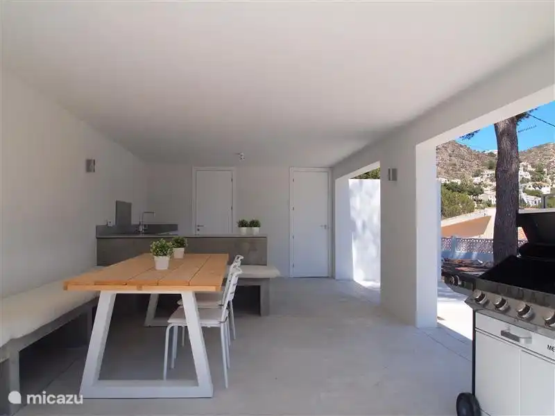 Outdoor-Küche mit Blick auf Terrasse, Pool und Garten